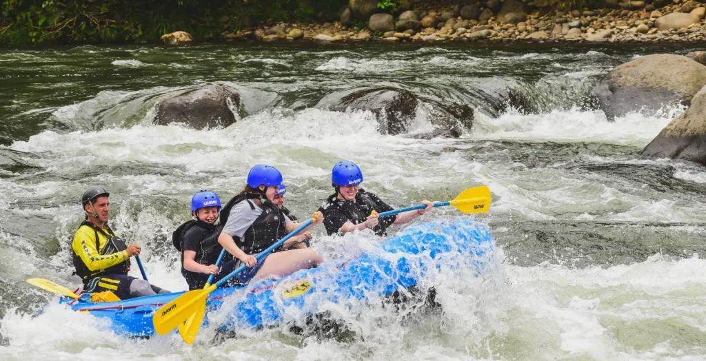 family rafting in la fortuna costa rica with wave expeditions guide in yellow shirt