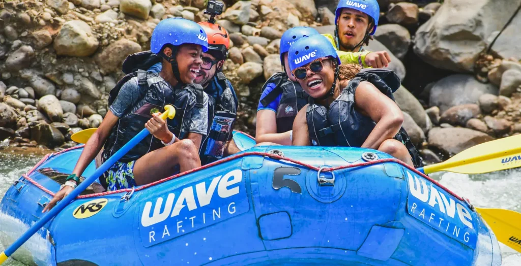 Family group smiling while rafting with Wave Expeditions in La Fortuna, Costa Rica